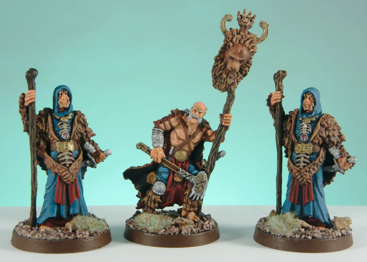 The Bear Clan leader between two mystics in turquoise robes against a turquoise background.